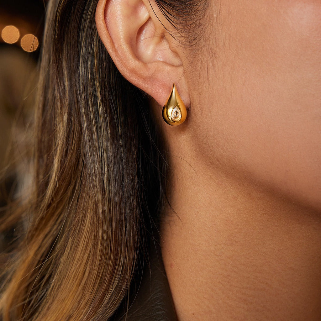 18K gold earrings inlaid with cubic zirconia in a teardrop design.