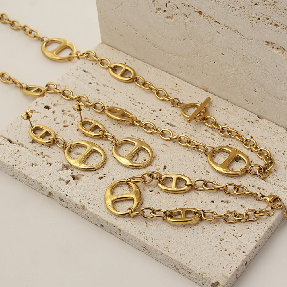 18K gold geometric-shaped necklace, bracelet, and earrings set.